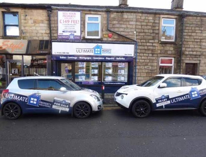 two company cars parked nose to nose outside the Ultimate Property Solutions office